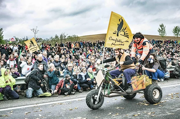 Photo joyeuse de lutte, avec inventivité, montrant également l'alliance avec la confédération paysanne pour défendre les terres agricoles. Contre l'artificialisation des sols!